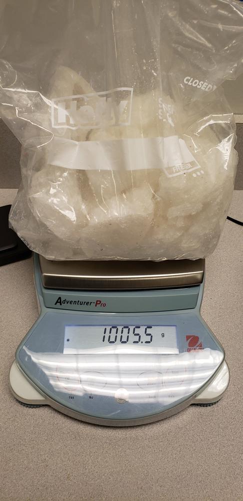 Seized drugs on a scale weighing 10,005.5 grams.