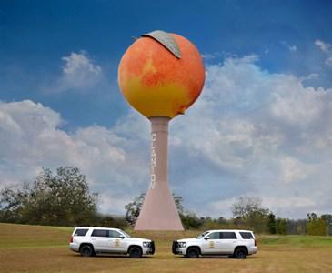 Two Chilton County Patrol Vehicles in front of the peach themed water tower.