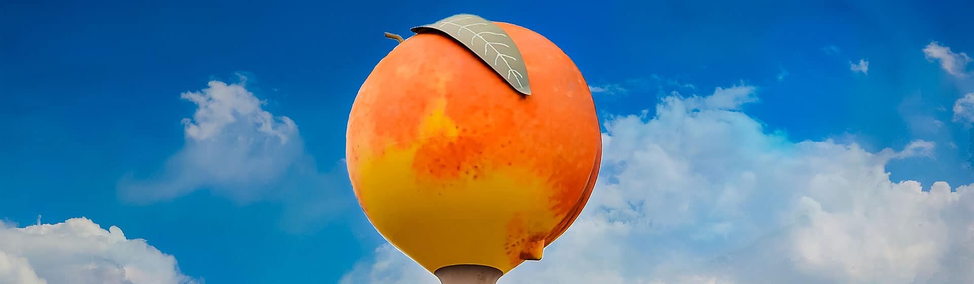 A water tower decorated and painted to look like a giant peach.